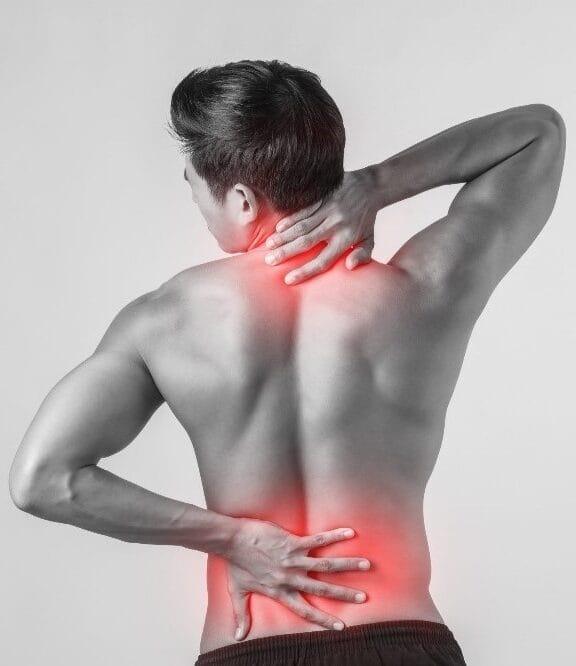 Physiotherapist performing back assessment and manual therapy on patient at home