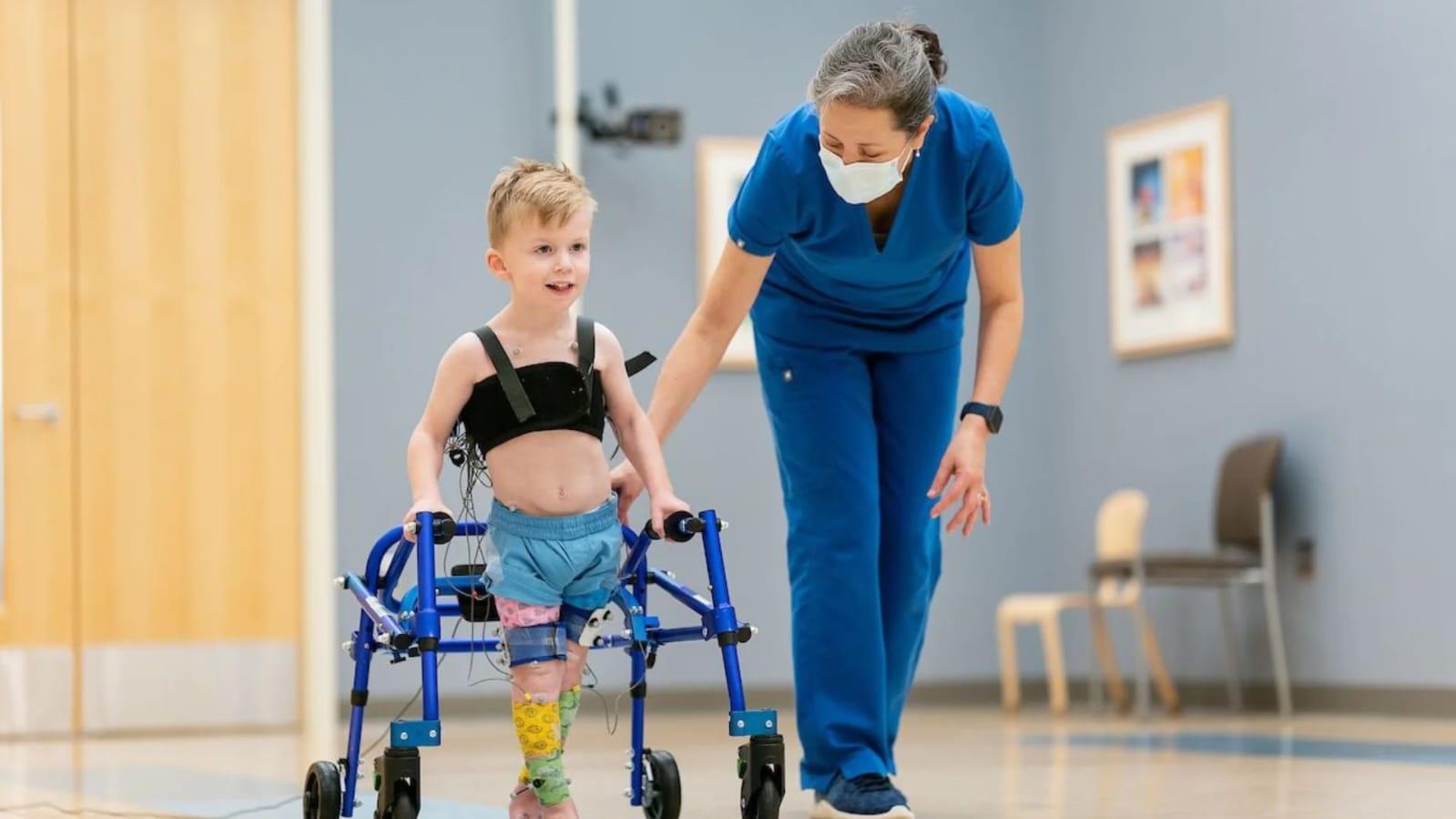 Pediatric physiotherapist working with child on balance and coordination exercises in a home setting